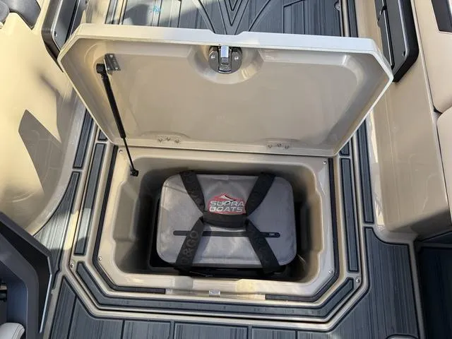 Slide: The Image of 2025 Supra SL 400 boat storage compartment with secured Supra Boats cooler. - 15