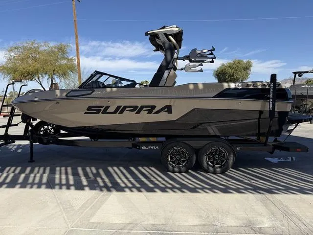 Slide: The Image of 2025 Supra SL 400 boat on trailer, sleek design, parked outdoors under clear sky. - 5