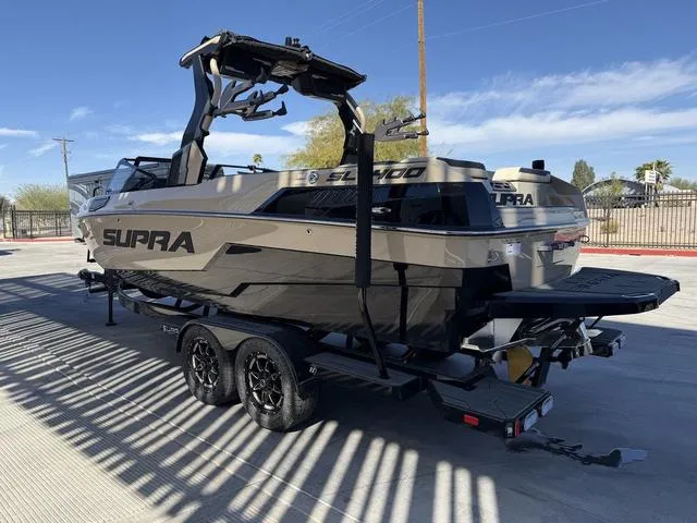 Slide: The Image of 2025 Supra SL 400 boat on trailer, sleek design, parked outdoors. - 6