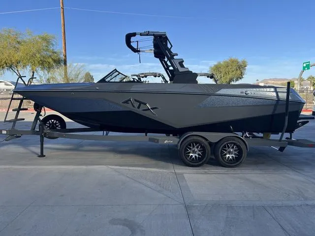 Slide: The Image of 2025 ATX Boats 24 TYPE-S on trailer, sleek black design, parked outdoors. - 5