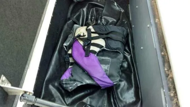 Slide: The Image of Purple and black life jacket stored in a compartment of a 2009 Centurion Elite V C4 Air Warrior. - 12
