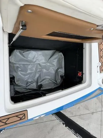 Slide: The Image of 2014 Tigé RZ2 storage compartment with gray cover and brown interior accents. - 13