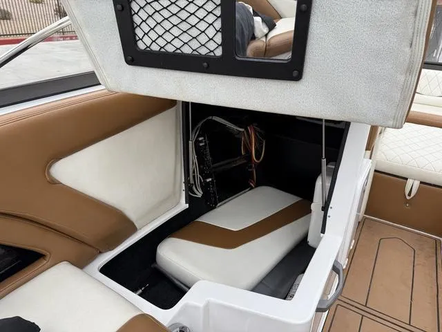 Slide: The Image of 2014 Tigé RZ2 boat interior storage compartment with brown and white seating. - 14