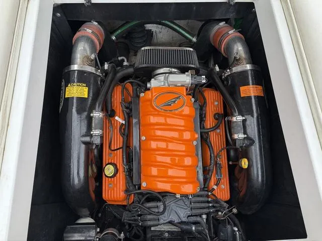 Slide: The Image of 2014 Tigé RZ2 boat engine with orange cover and dual exhaust pipes. - 16