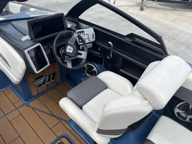 Slide: The Image of 2021 Malibu 23 MXZ boat interior with modern dashboard and white seating. - 11