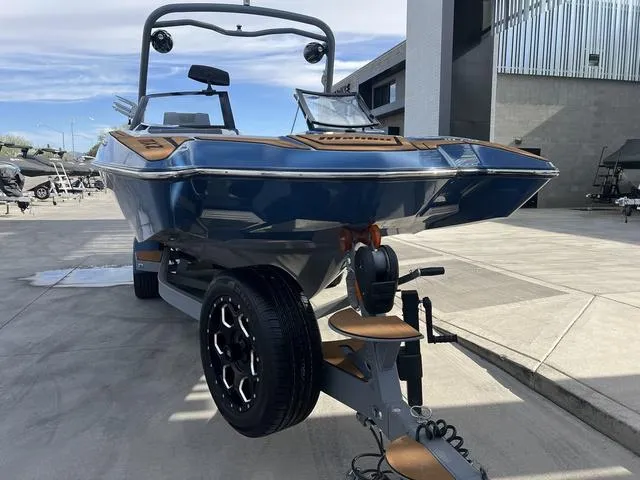 Slide: The Image of 2021 Malibu 23 MXZ boat on trailer, parked outdoors. - 3