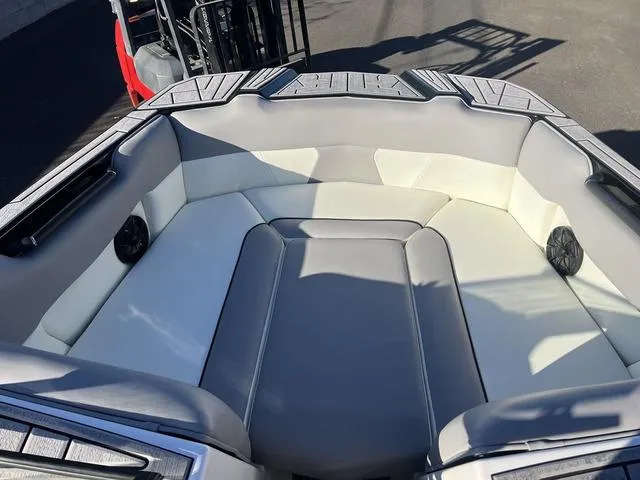 Slide: The Image of 2023 Moomba Max boat interior with gray and white seating, featuring built-in speakers. - 11