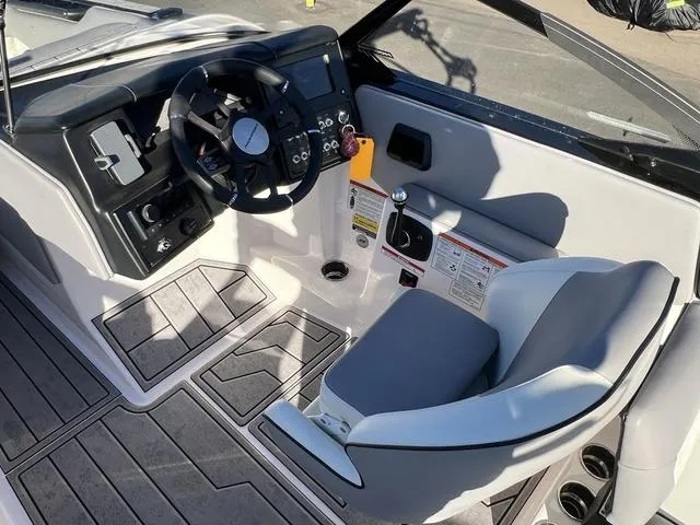 Slide: The Image of 2023 Moomba Max boat interior with steering wheel and seating area. - 12