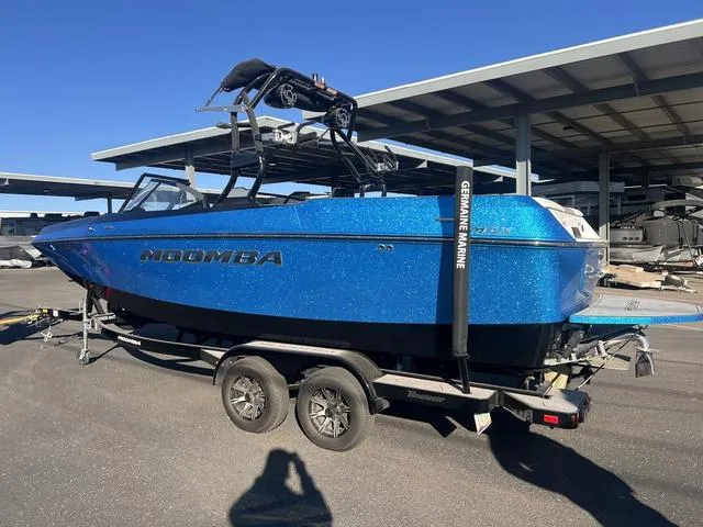 Slide: The Image of 2023 Moomba Max boat in vibrant blue on a trailer, parked outdoors. - 3
