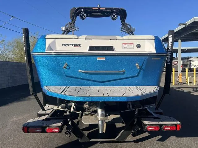 Slide: The Image of 2023 Moomba Max boat, rear view, blue exterior, featuring Raptor engine. - 4