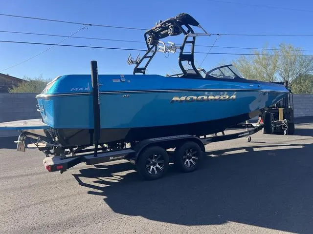 Slide: The Image of 2023 Moomba Max boat on trailer, blue exterior, parked outdoors. - 5
