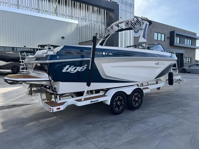 Slide: The Image of 2020 Tigé 25ZX boat on trailer, parked outdoors near modern buildings. - 3