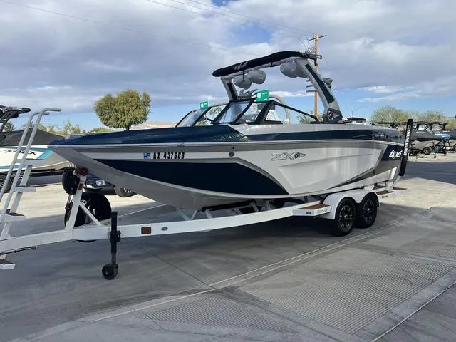 Slide: The Image of 2020 Tigé 25ZX boat on trailer, parked outdoors under cloudy sky. - 4