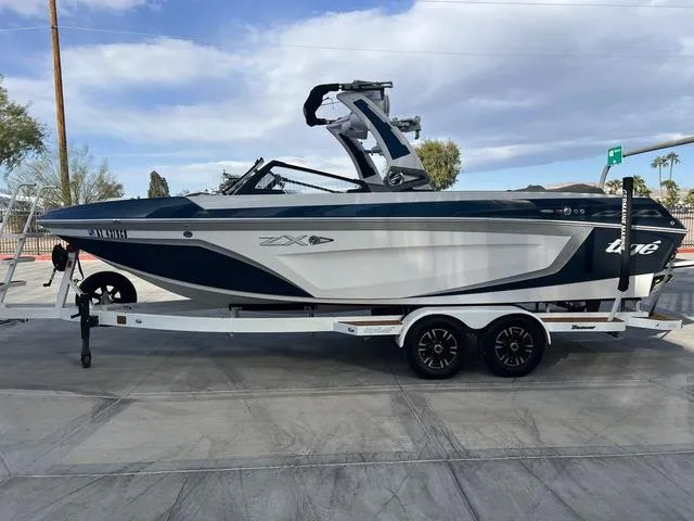 Slide: The Image of 2020 Tigé 25ZX boat on trailer, side view, outdoors under cloudy sky. - 5