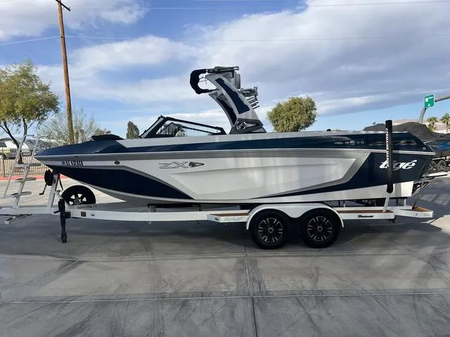 Slide: The Image of 2020 Tigé 25ZX boat on trailer, parked outdoors under a cloudy sky. - 7