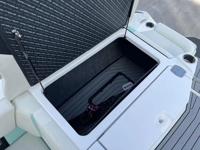 Slide: The Image of 2023 Nautique Super Air Nautique G25 storage compartment with open lid, showcasing interior space. - 15