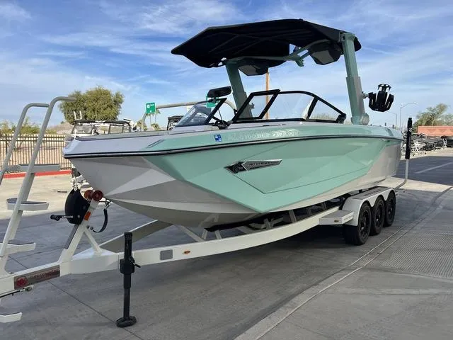 Slide: The Image of 2023 Nautique Super Air Nautique G25 boat on trailer, mint green hull, parked outdoors. - 4