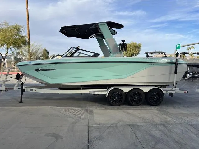 Slide: The Image of 2023 Nautique Super Air Nautique G25 boat on trailer, mint green hull, black canopy. - 5