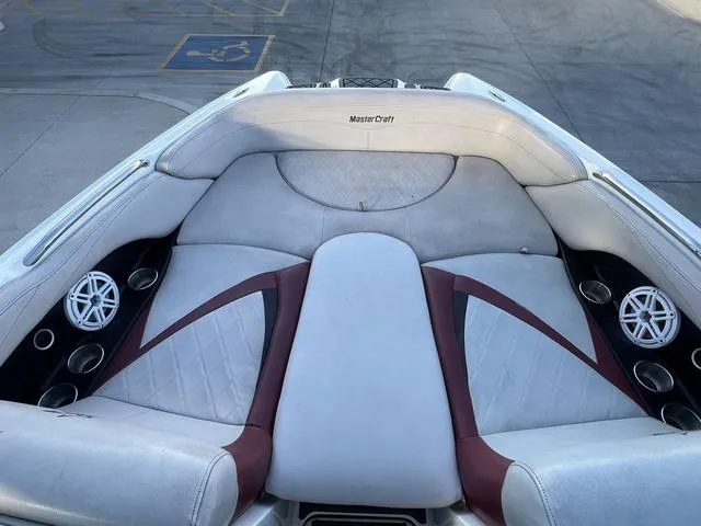 Slide: The Image of 2010 MasterCraft X45 boat interior with white and maroon seating, cup holders, and speakers. - 10