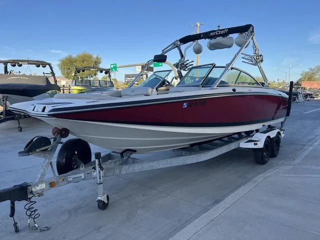 Slide: The Image of 2010 MasterCraft X45 boat on trailer, red and white, parked outdoors. - 4