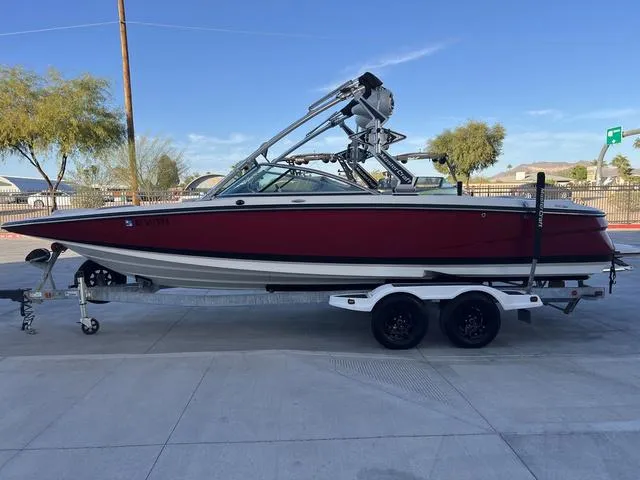 Slide: The Image of 2010 MasterCraft X45 boat on trailer, red and white, parked outdoors. - 5