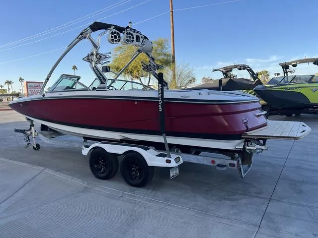 Slide: The Image of 2010 MasterCraft X45 boat on trailer, red hull, wakeboard tower, parked outdoors. - 6