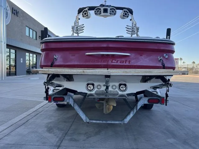 Slide: The Image of 2010 MasterCraft X45 boat, rear view, red hull, parked on a trailer in a lot. - 7