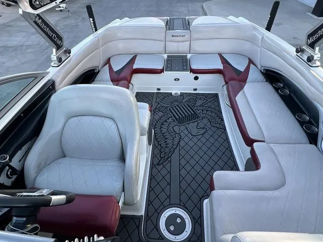 Slide: The Image of 2010 MasterCraft X45 boat interior with white and red seating, stylish design, and spacious layout. - 8