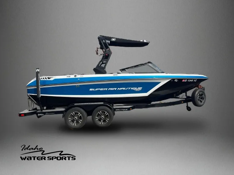 Slide: The Image of 2020 Nautique GS22 boat on trailer, blue and white, Idaho Water Sports logo. - 1