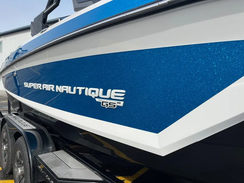 Slide: The Image of 2020 Nautique GS22 boat with blue and white exterior on a trailer. - 13