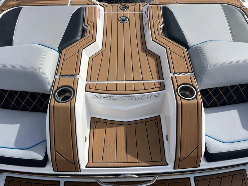 Slide: The Image of 2020 Nautique GS22 boat deck with cushioned seating and cup holders. - 15