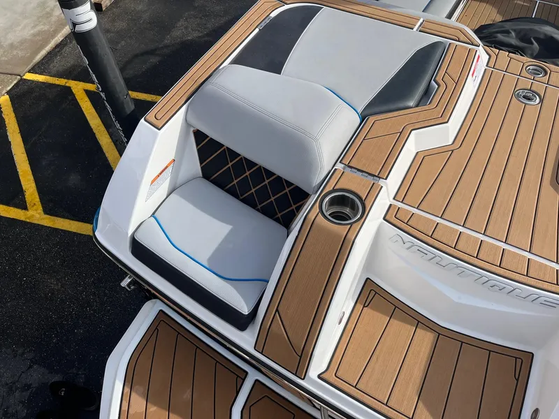 Slide: The Image of 2020 Nautique GS22 boat with teak deck and cushioned seating. - 16