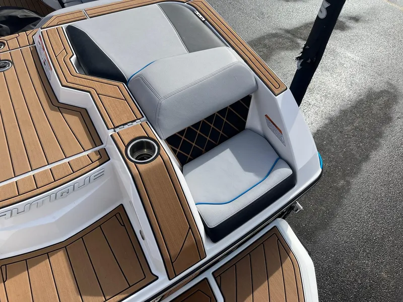 Slide: The Image of 2020 Nautique GS22 boat interior with teak flooring and cushioned seating. - 17