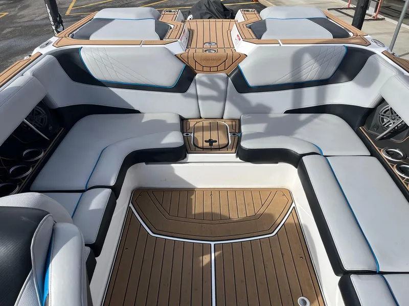 Slide: The Image of 2020 Nautique GS22 boat interior with cushioned seating and teak flooring. - 19
