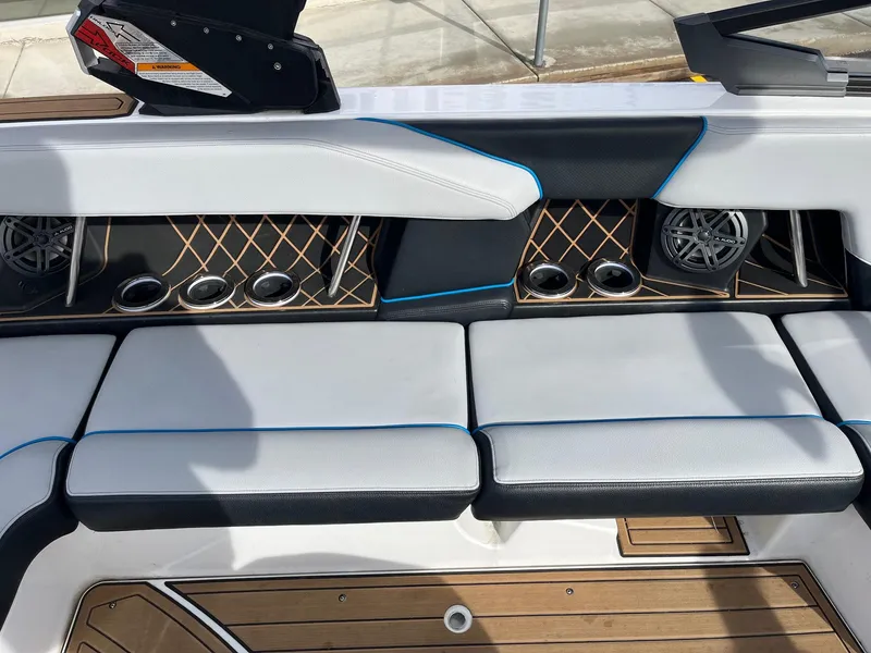 Slide: The Image of 2020 Nautique GS22 boat interior with cushioned seating and cup holders. - 24