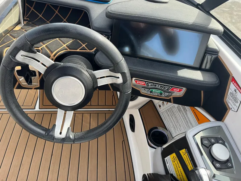 Slide: The Image of 2020 Nautique GS22 boat dashboard with steering wheel and control panel. - 28