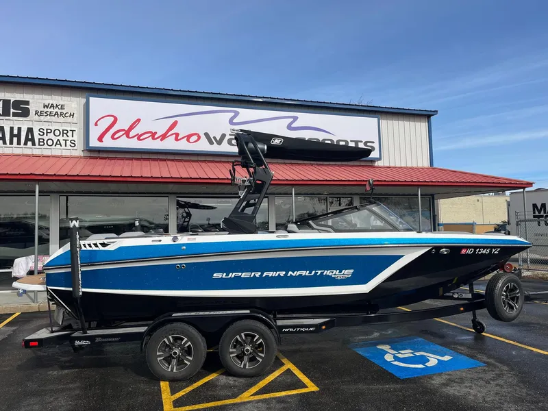 Slide: The Image of 2020 Nautique GS22 boat in blue, parked outside Idaho Water Sports dealership. - 3