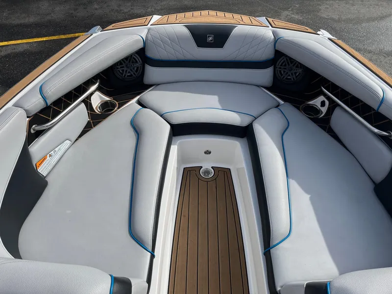 Slide: The Image of 2020 Nautique GS22 boat interior with cushioned seating and wood accents. - 33