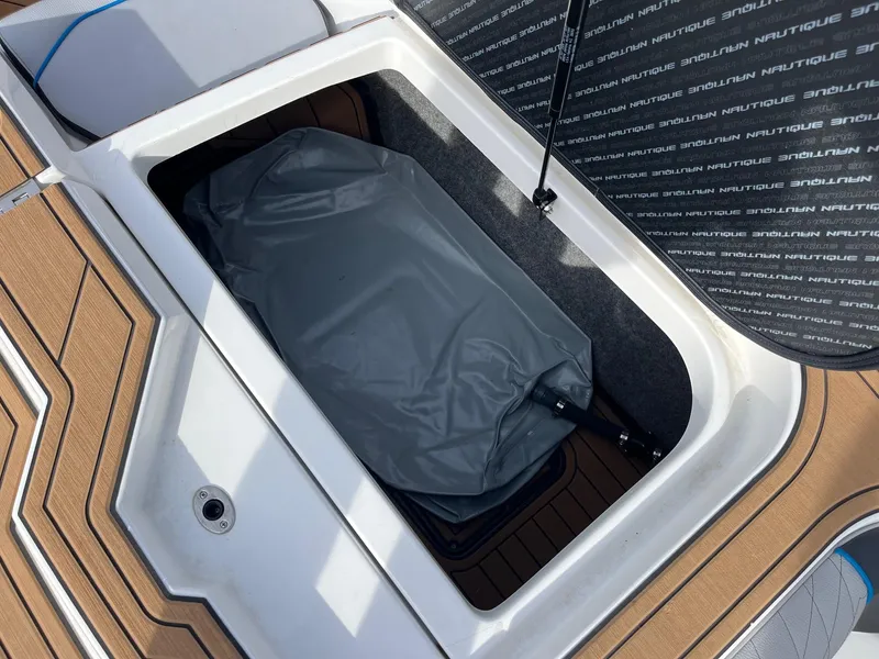 Slide: The Image of Open storage compartment in 2020 Nautique GS22 boat, showing interior details and equipment. - 36