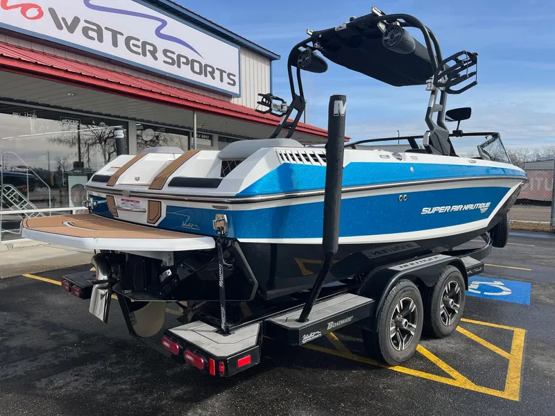 Slide: The Image of 2020 Nautique GS22 boat in blue, parked outside a water sports store. - 4
