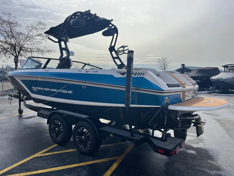 Slide: The Image of 2020 Nautique GS22 boat on trailer, blue and white design, parked outdoors. - 7