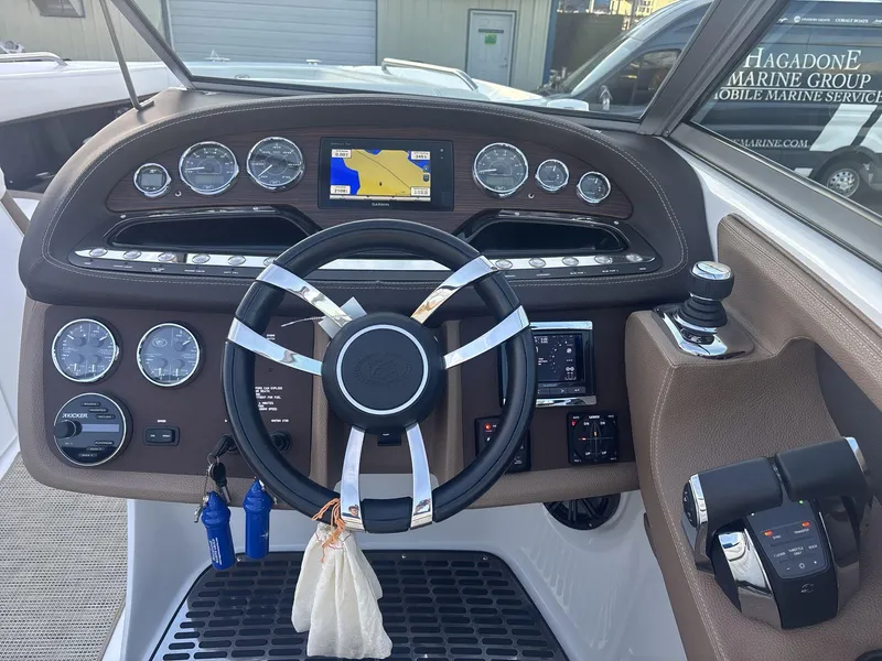 Slide: The Image of 2016 Cobalt 302 boat dashboard with steering wheel and navigation controls. - 11