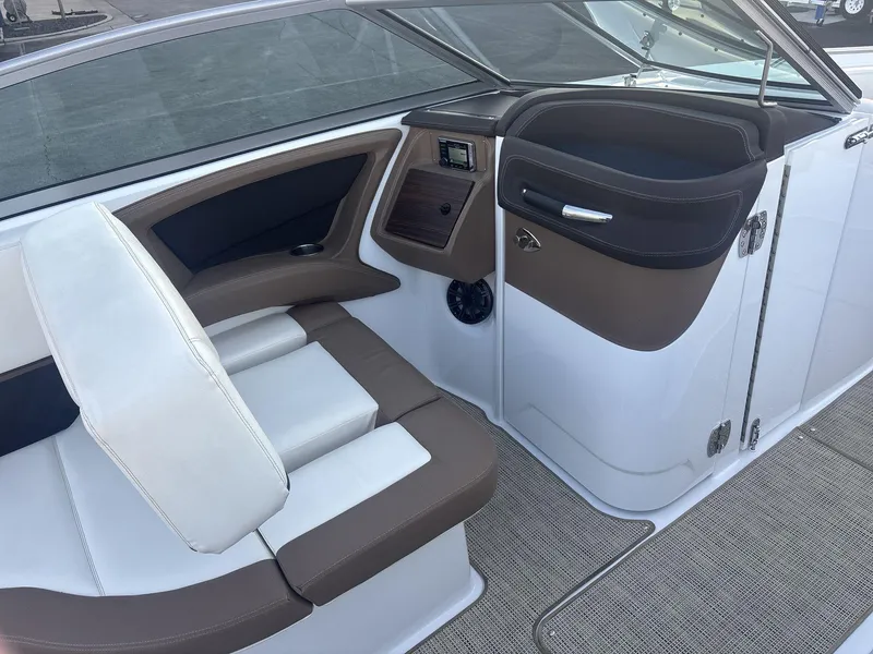 Slide: The Image of Interior of a 2016 Cobalt 302 boat, featuring white and brown seating and dashboard. - 13