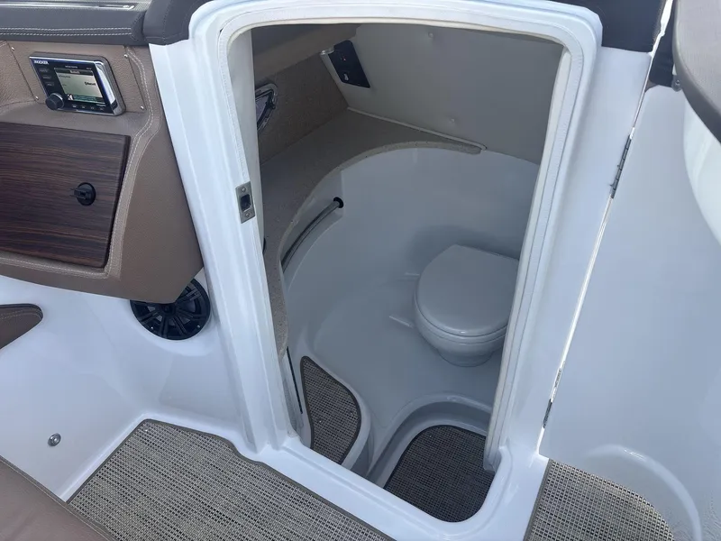 Slide: The Image of Interior of a 2016 Cobalt 302 boat featuring a compact marine toilet. - 14
