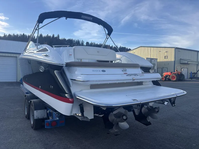 Slide: The Image of 2016 Cobalt 302 boat on trailer, parked outdoors near industrial buildings. - 4