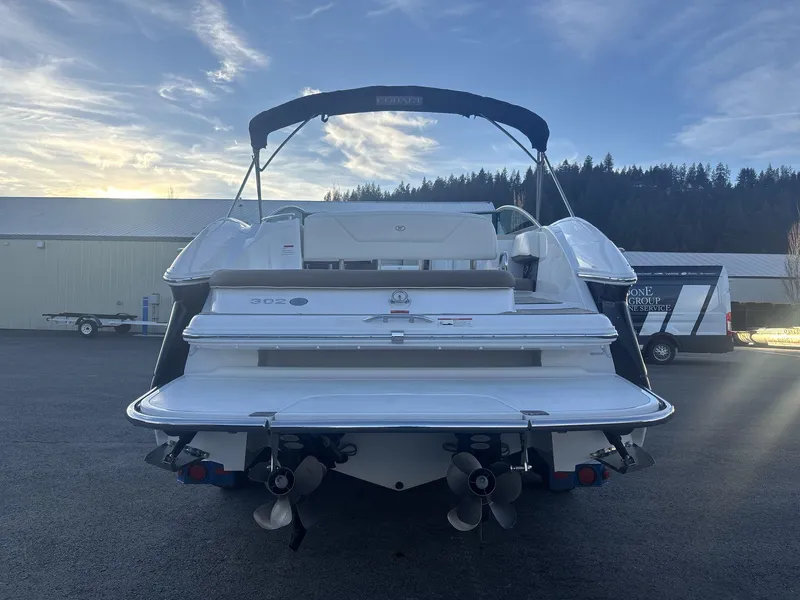 Slide: The Image of 2016 Cobalt 302 boat, rear view, parked outdoors with scenic background. - 5