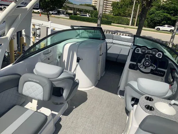 Slide: The Image of 2024 NauticStar 243 DC boat interior with modern seating and steering console. - 3