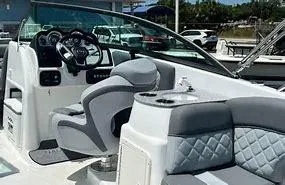 Slide: The Image of 2024 NauticStar 243 DC boat interior with modern seating and steering console. - 4