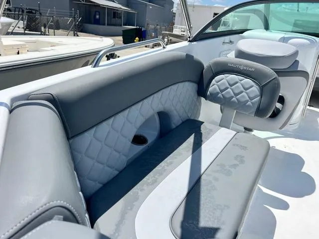 Slide: The Image of 2024 NauticStar 243 DC boat interior with gray quilted seating and modern design. - 5