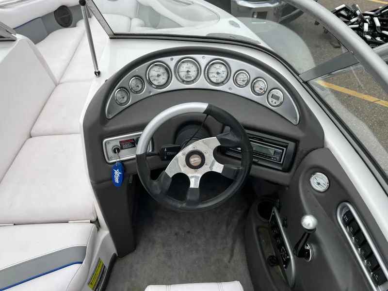 Slide: The Image of 2004 Supra Launch boat dashboard with steering wheel and instrument panel. - 12